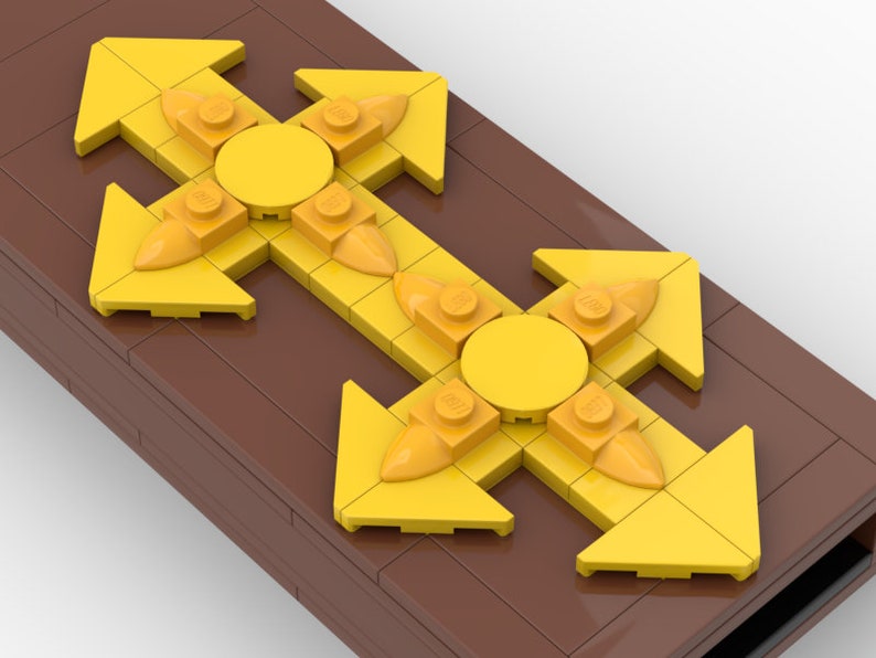 May include: Two yellow LEGO arrow pieces with a round yellow LEGO piece in the center of each. The arrows are pointing in four directions: up, down, left, and right. The LEGO pieces are on a brown surface.