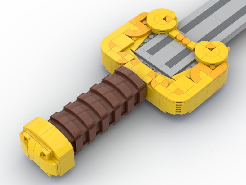 May include: A yellow and brown Lego sword with a detailed handle and a silver blade.