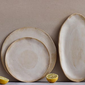 In front of one wall are two plates and an oval platter in matte white glazed stoneware.