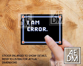 May include: A black sticker with the text "I AM ERROR" in white pixelated font, framed by a blue border. The sticker is held by a hand against a wooden background. The text "STICKER ENLARGED TO SHOW DETAILS. REFER TO LISTING FOR ACTUAL DIMENSIONS" is also visible.