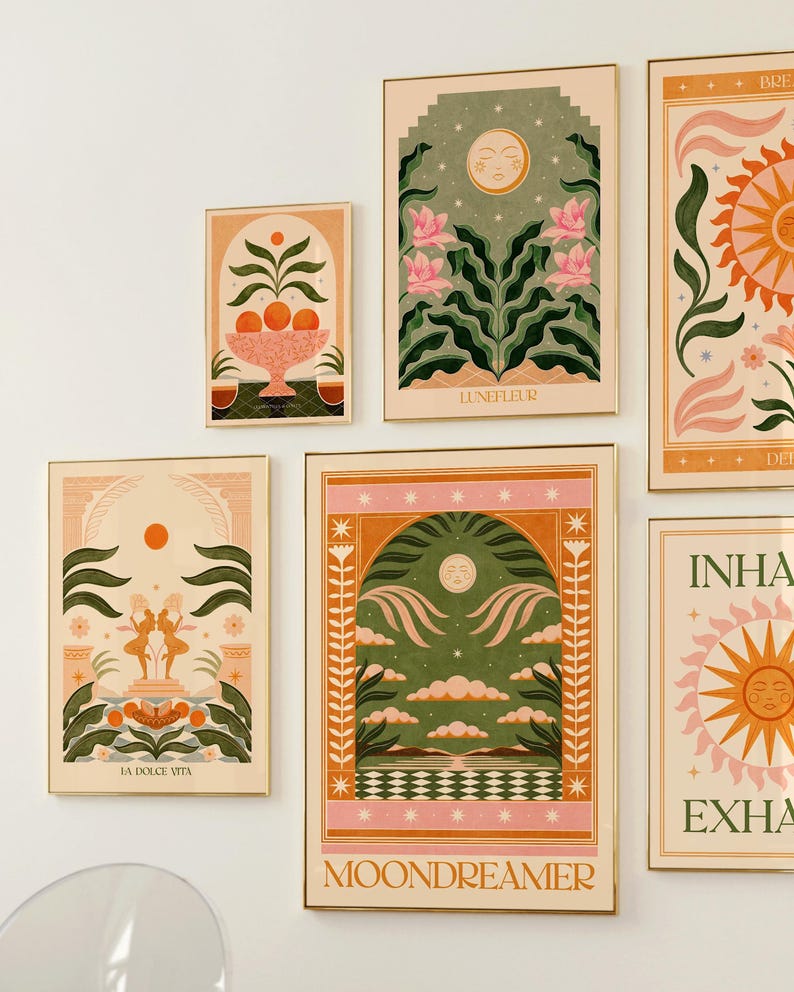 May include: A set of nine framed prints with a vintage aesthetic. The prints feature illustrations of moons, suns, flowers, and other nature-inspired elements. The prints are in a variety of colours, including pink, green, yellow, and orange. The prints are all framed in gold.