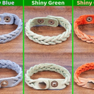 May include: Three braided leather bracelets with silver snap closures. The bracelets are shown in three colours: shiny blue, shiny green, and shiny orange.