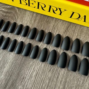 Könnte beinhalten: Ein Set mit 20 schwarzen matten ovalen falschen Nägeln.