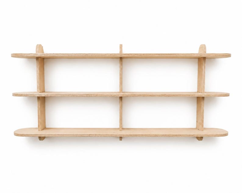 May include: A wall-mounted light-colored wooden shelving unit featuring three horizontal shelves with rounded ends. The structure is supported by three vertical dividers that intersect the shelves, creating six distinct storage compartments.