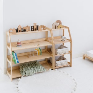 May include: Two wooden shelves with multiple shelves, one on top of the other. The shelves are filled with wooden toys, books, and baskets. The shelves are made of light wood and have a natural finish.