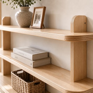 Large wooden wall shelf styled above a sofa in a warm, modern living room with neutral décor.