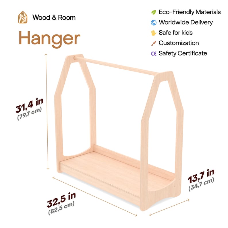 Op de afbeelding: Een houten kledinghanger voor kinderkleding, in de vorm van een huis met een plank. Hij is 79,7 cm hoog, 82,5 cm breed en 34,7 cm diep.