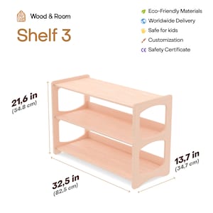 May include: A light-colored wooden three-tier shelf with open sides. The text Wood & Room Shelf 3 is visible. Dimensions are 21.6 inches high, 32.5 inches wide, and 13.7 inches deep. The design features smooth, rounded side panels.