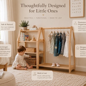 May include: A light-colored wooden open-frame clothing rack and shelving unit featuring a house-shaped silhouette. The unit includes a hanging rod with several small garments, three open shelves holding books and woven baskets, and a bottom shelf.