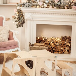 May include: A wooden children's table and chairs set with a unique cutout design. The table and chairs are made of natural wood and have a light brown finish. The set is perfect for a playroom or a child's bedroom.