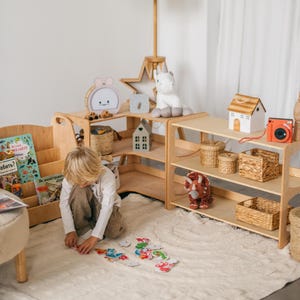 May include: A child plays with colorful animal shaped puzzle pieces on a white rug in a playroom. The room features wooden shelves with books, toys, and storage baskets. The shelves are arranged in a corner of the room.