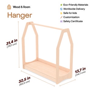 May include: A light-colored wooden clothing hanger rack with a house-shaped frame, featuring a horizontal bar and a base shelf. The rack measures 31.4 inches in height, 32.5 inches in width, and 13.7 inches in depth, labeled Wood & Room Hanger.