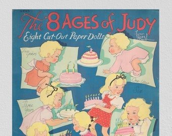 Op de afbeelding: Een vintage set papieren poppen met acht verschillende leeftijden van een meisje genaamd Judy. Elke pop houdt een verjaardagstaart vast met kaarsen, en de poppen zijn gekleed in verschillende outfits. De titel van de set is "The 8 Ages of Judy" en "Eight Cut-Out Paper Dolls".