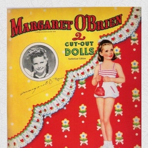 Könnte beinhalten: Ein Vintage-Papierpuppenbuch mit Margaret O'Brien, einem Star von Metro-Goldwyn-Mayer. Der Umschlag zeigt einen roten und weißen Hintergrund mit einer weißen Spitzenborte und einem gelben Rand. Der Buchtitel lautet "2 Cut-Out Dolls" mit dem Text "Authorized Edition" darunter.
