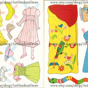 May include: A paper doll set with a variety of outfits and accessories. The set includes a sleeping bag with a floral design, a blue quilted robe, a yellow dress with floral print, a pink and white striped dress, a green and white checkered dress, and a white dress with blue and red trim. The set also includes a variety of hats and shoes.