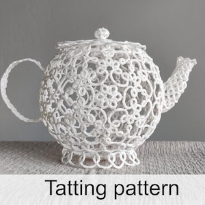 May include: A white teapot crafted from intricate lace tatting, featuring a delicate floral and geometric openwork pattern. The teapot includes a matching lid, a curved handle, and a spout, all constructed from fine white thread in a tatting pattern.
