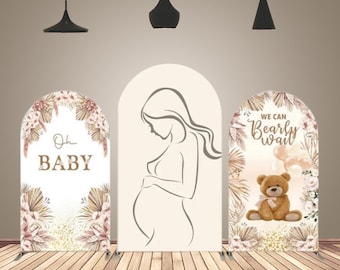May include: Three arch-shaped baby shower backdrops with a boho theme. The left backdrop features a floral design with the text "Oh Baby". The center backdrop features a silhouette of a pregnant woman. The right backdrop features a teddy bear with balloons and the text "We can Bearly Wait".