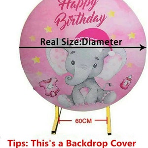 K&ouml;nnte beinhalten: Eine rosa Hintergrundabdeckung mit einem Durchmesser von 60 cm, mit einem Cartoon-Elefanten mit Weihnachtsm&uuml;tze, Sternen und Baby-Illustrationen. Der Text "Happy Birthday" wird oben angezeigt.