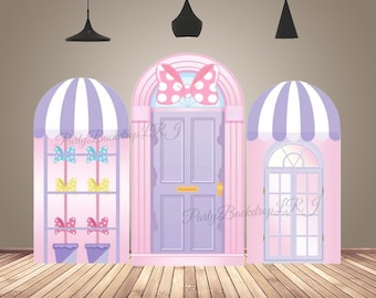 Décoration murale arquée pour baby shower, avec une porte rose et un nœud papillon en forme d'arche de maison en bonbons.