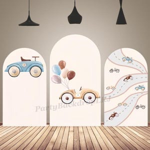 May include: Three arched backdrop panels featuring watercolor illustrations of vintage toy cars. The left panel shows a blue car, the center panel displays a tan car with balloons, and the right panel features a winding road with multiple small toy cars.