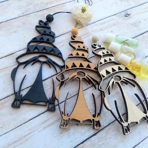 Könnte beinhalten: Drei Holz-Gnom-Ornamente mit geometrischen Mustern auf ihren Hüten. Die Gnome sind in Schwarz, Braun und Naturholz bemalt.