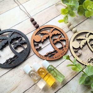 May include: Three wooden palm tree ornaments with the text "Every summer has a story" hanging from twine with brown and beige beads. The ornaments are in black, brown, and natural wood. Three small glass bottles with clear, yellow, and green liquids are in the foreground.