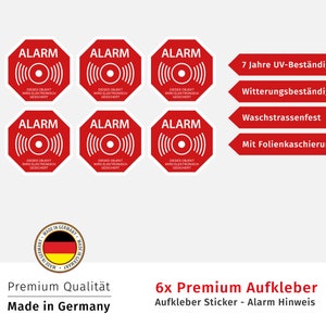 Może przedstawiać: Sześć czerwono-białych naklejek alarmowych z tekstem "ALARM" i "DIESES OBJEKT WIRD ELEKTRONISCH GESICHERT" w języku niemieckim. Naklejki są odporne na warunki atmosferyczne, promieniowanie UV i nadają się do mycia. Są produkowane w Niemczech.