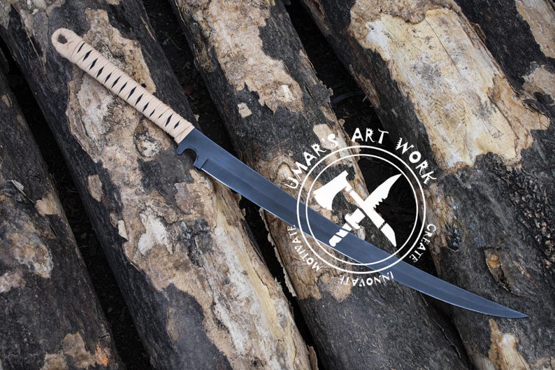 K&ouml;nnte beinhalten: Ein Messer mit schwarzer Klinge und einem beige umwickelten Griff. Das Messer liegt auf einem Stapel Holzscheite. Das Messer hat eine gerade Kante und eine Spitze. Das Bild enth&auml;lt ein wei&szlig;es kreisf&ouml;rmiges Logo mit dem Text "UMAR'S ART WORK".