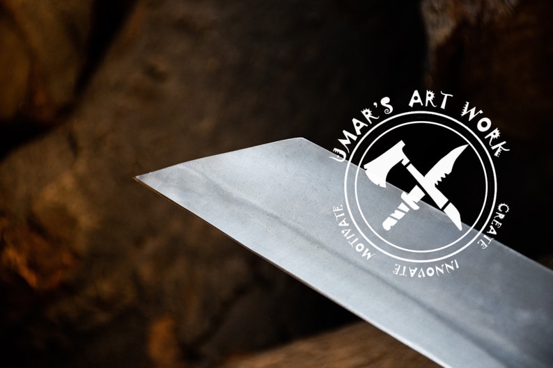 K&ouml;nnte beinhalten: Nahaufnahme einer scharfen, silbernen Klinge mit einem runden Logo, auf dem "UMAR'S ART WORK" steht, umgeben von den W&ouml;rtern "MOTIVATE", "INNOVATE" und "CREATE". Das Logo zeigt eine gekreuzte Axt und ein Messer.