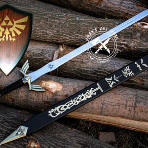 May include: A wooden shield with a gold emblem, a silver sword, and a black scabbard with silver designs. The sword has a silver hilt and a blue blade. The items are displayed on a background of wooden logs.
