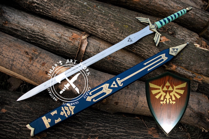May include: A fantasy sword with a blue and white handle, silver blade, and gold accents, along with a matching blue sheath and a wooden shield. The sword and shield are displayed on a background of wooden logs. The image includes the text "UMAR'S ART WORK".
