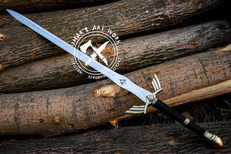 May include: A silver-bladed sword with a black handle and gold accents, resting on a pile of logs. The sword features a distinctive hilt design and a Triforce symbol on the blade. The text "UMAR'S ART WORK" is in a circular logo.