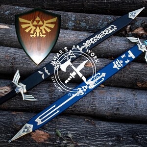 May include: A wooden shield with a gold emblem and two decorative swords, one black and one blue, with silver accents. The swords and shield are displayed on a background of stacked logs. The image includes the text "AMAR'S ART WORK MOTIVATE".