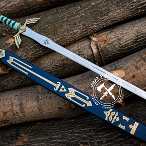 May include: A silver sword with a blue and gold handle and a matching blue sheath, resting on a bed of wooden logs. The sword features a stylized design with gold accents and a triangular emblem on the blade. The sheath has gold decorative elements.