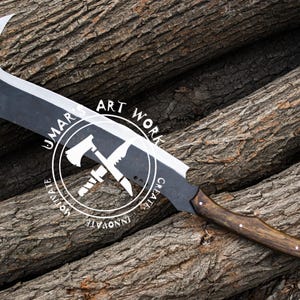 K&ouml;nnte beinhalten: Eine gro&szlig;e, schwarz-silberne Klinge mit gebogener Spitze und Holzgriff. Die Klinge hat eine einzigartige Form und ist vor dem Hintergrund strukturierter Holzst&auml;mme platziert. Der Text "UMAR ART WORK" ist sichtbar.