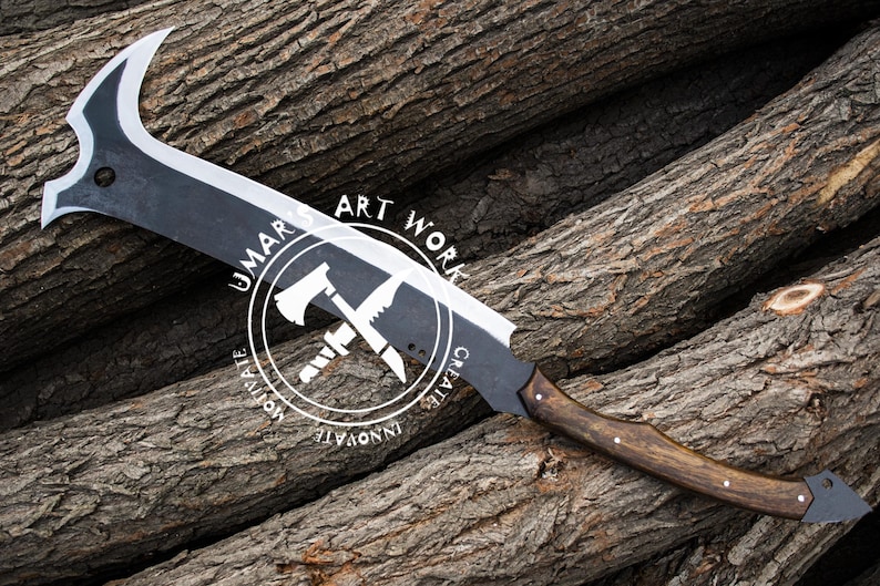 K&ouml;nnte beinhalten: Eine gro&szlig;e, schwarz-silberne Klinge mit gebogener Spitze und Holzgriff. Die Klinge hat eine einzigartige Form und ist vor dem Hintergrund strukturierter Holzst&auml;mme platziert. Der Text "UMAR ART WORK" ist sichtbar.