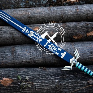May include: A blue and silver decorative sword with a teal and silver handle. The sword features a design on the blade and handle. The image includes the text "MAR'S ART WORK" in a circular logo.