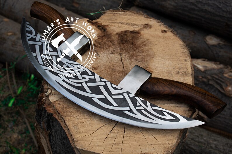 May include: A curved blade with a dark wood handle and a silver metal edge featuring an intricate etched Celtic knot pattern. The blade is marked with a circular logo containing the text UMAR'S ART WORK, MOTIVATE, CREATE, and INNOVATE.