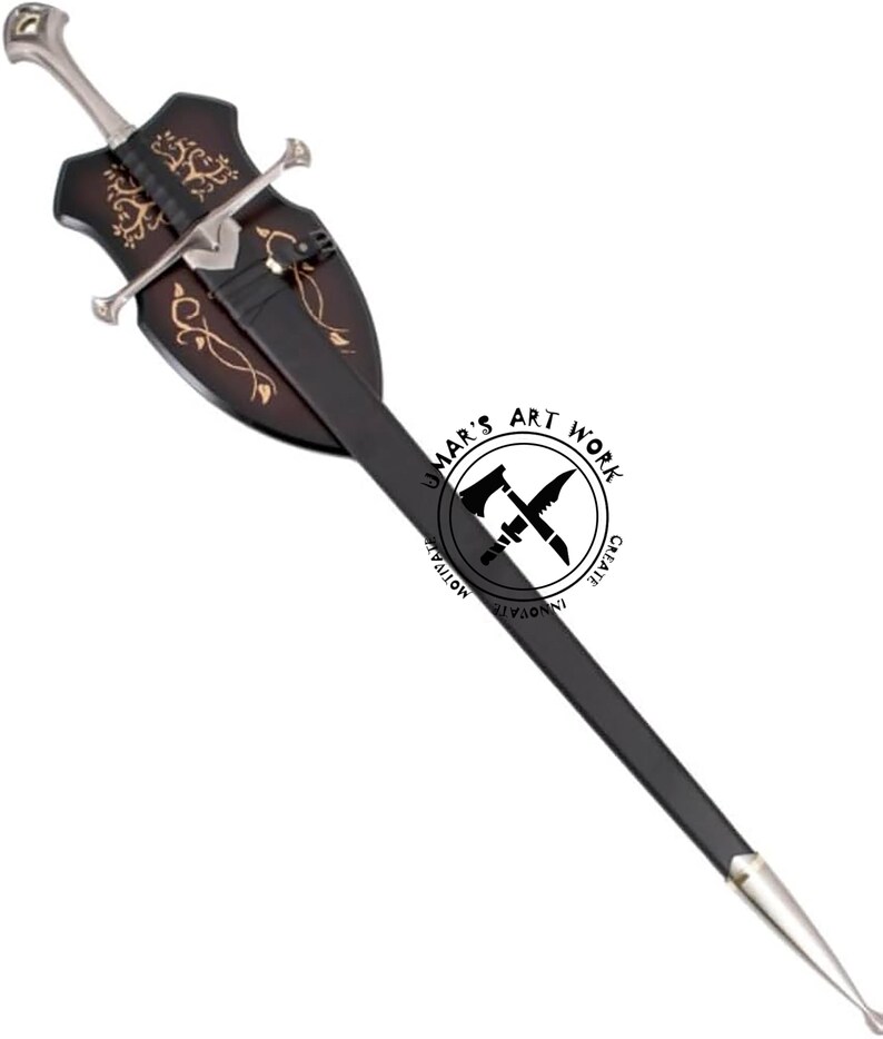 May include: A decorative sword with a silver blade and handle, and a black scabbard. The sword is mounted on a dark brown wooden plaque with gold-colored decorative accents. The plaque has a shield shape. The text "UMAR'S ART WORK" is visible.