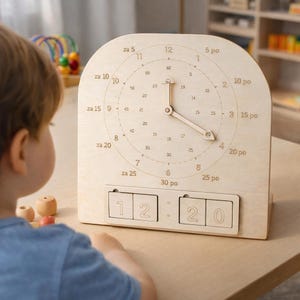 Könnte beinhalten: Eine Lernuhr aus hellem Holz. Das Zifferblatt hat Zahlen und Minutenmarkierungen. Die Zeiger zeigen auf 4:20. Darunter befinden sich zwei Zahlenblöcke, die die Uhrzeit anzeigen.