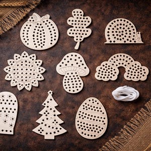 Pode incluir: Uma coleção de formas de madeira para amarrar, incluindo uma abóbora, folha, caracol, girassol, cogumelo, arco-íris, luva, árvore de Natal e ovo. Cada forma tem orifícios pré-perfurados para enfiar. Um fio branco também está incluído.