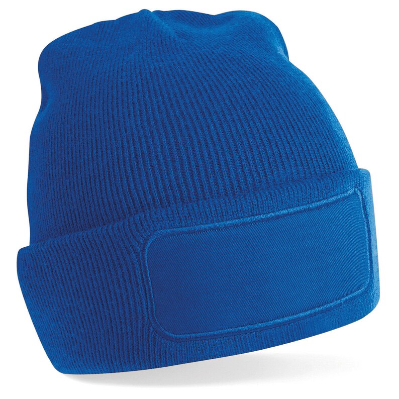 Puede incluir: Un gorro de punto azul real con un parche grande y en blanco en la parte delantera. El gorro est&aacute; hecho de un material suave y c&aacute;lido, perfecto para mantener la cabeza caliente en invierno.