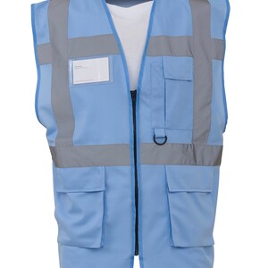 May include: A light blue safety vest with reflective strips and multiple pockets. The vest has a zip closure and a name tag holder.