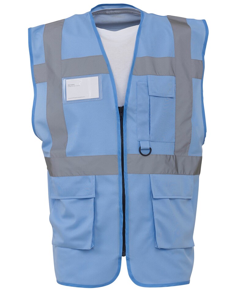 May include: A light blue safety vest with reflective strips and multiple pockets. The vest has a zip closure and a name tag holder.