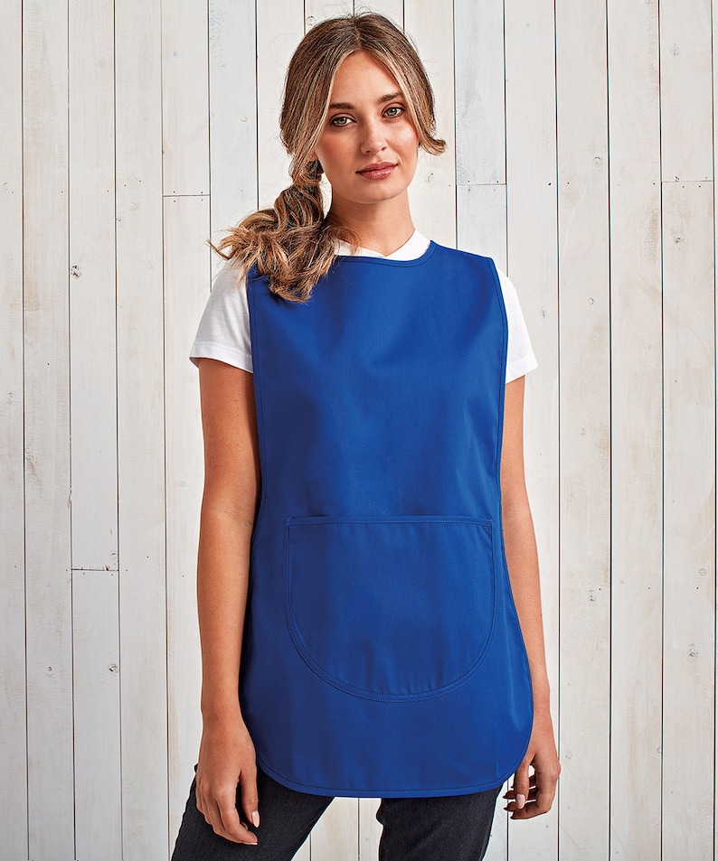 May include: A royal blue sleeveless apron with a single large pocket on the front. The apron is made of a smooth, durable fabric.