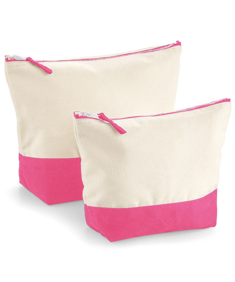 May include: Two canvas zippered pouches with pink trim. The larger pouch is behind the smaller pouch.