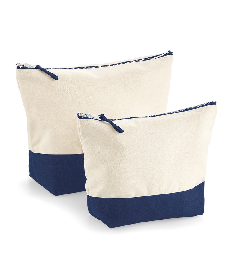 May include: Two canvas zippered pouches with a navy blue bottom. The larger pouch is behind the smaller pouch.