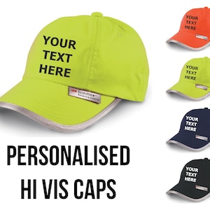 May include: A selection of personalised hi-vis caps in neon yellow, orange, navy, and black. Each cap displays the text "YOUR TEXT HERE" and has a reflective brim. These caps are designed for high visibility and safety.
