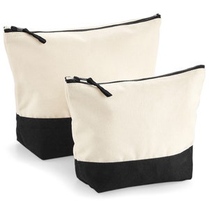 May include: Two canvas zippered pouches with black bottoms. The larger pouch is behind the smaller pouch.
