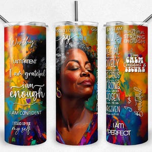 May include: A set of three stainless steel tumblers with colorful abstract art and inspirational text. The tumblers feature a portrait of a woman and phrases like "I am worthy" and "I am beautiful."